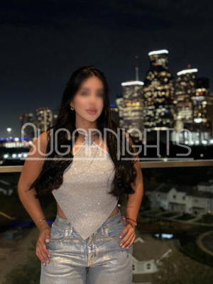 Merlina Morales posing at night with the Houston skyline in the background Merlina Morales posing at night with the Houston skyline in the background